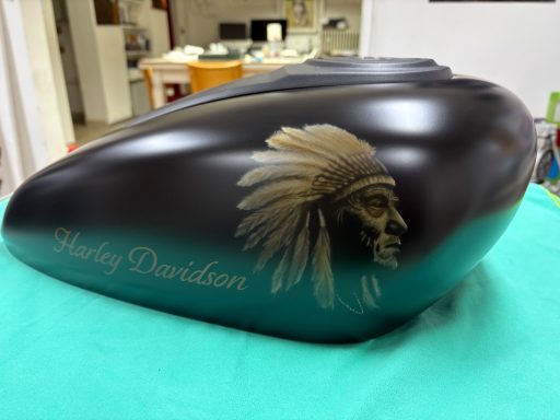 Schwarzer Motorradtank mit Indianer-Motiv und "Harley Davidson"-Schriftzug.